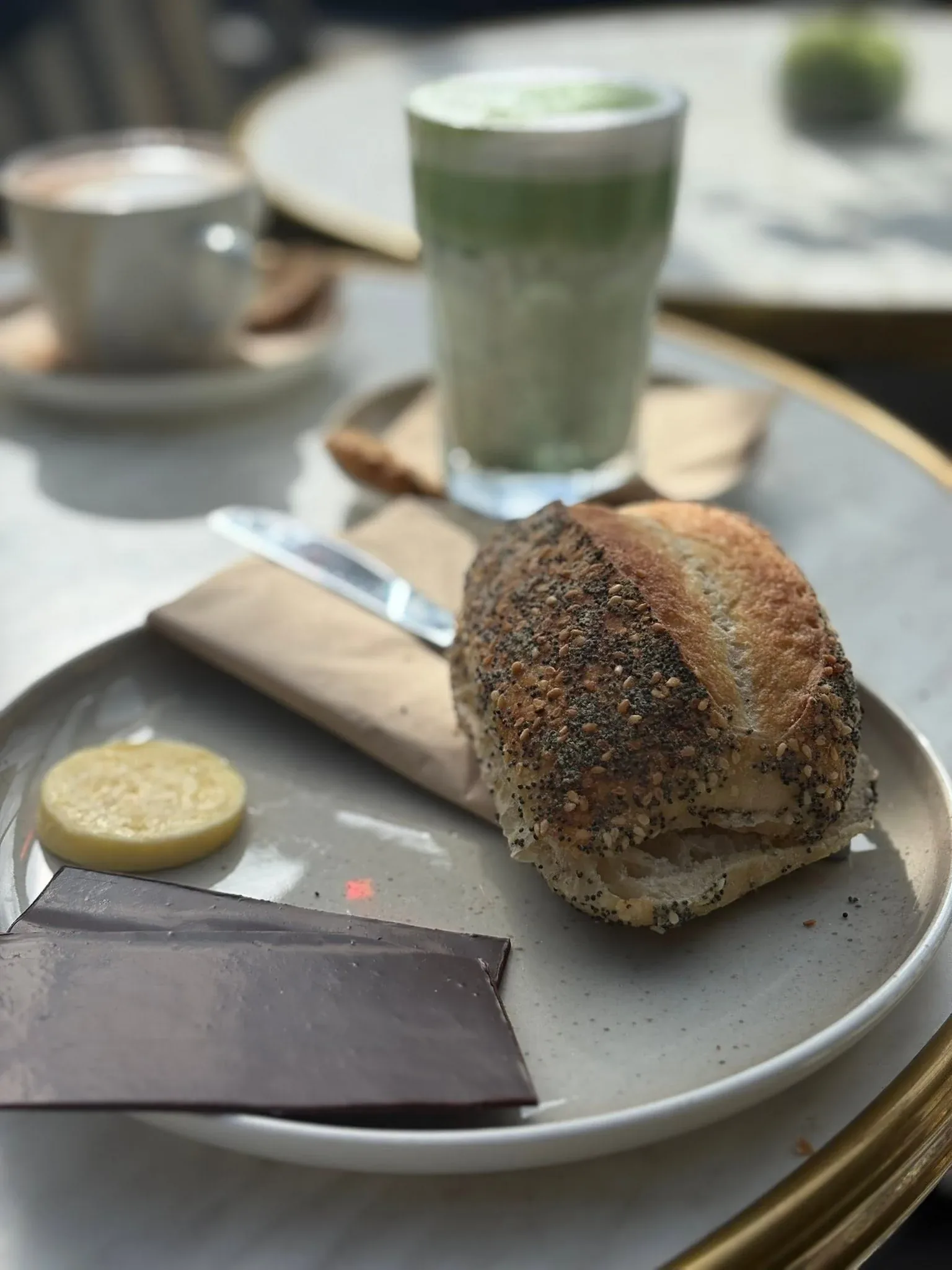 Friskbagt morgenbrød med ost, smør og chokolade ved siden af kaffe og matcha